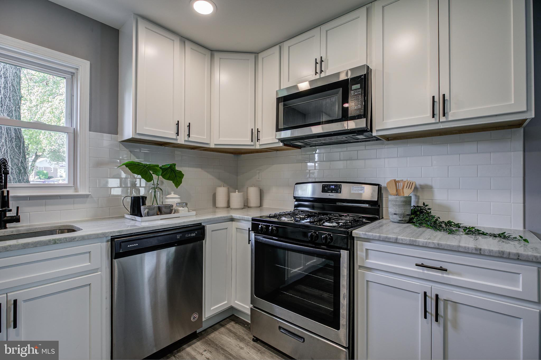 7410 Remoor Road Baltimore, MD 21207 - Photo 13 of 33 a kitchen with stainless steel appliances granite countertop a sink a stove a microwave and cabinets