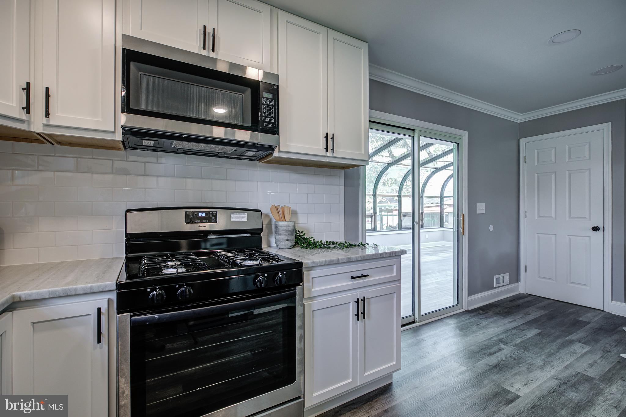 7410 Remoor Road Baltimore, MD 21207 - Photo 14 of 33 a kitchen with stainless steel appliances a stove a microwave and cabinets
