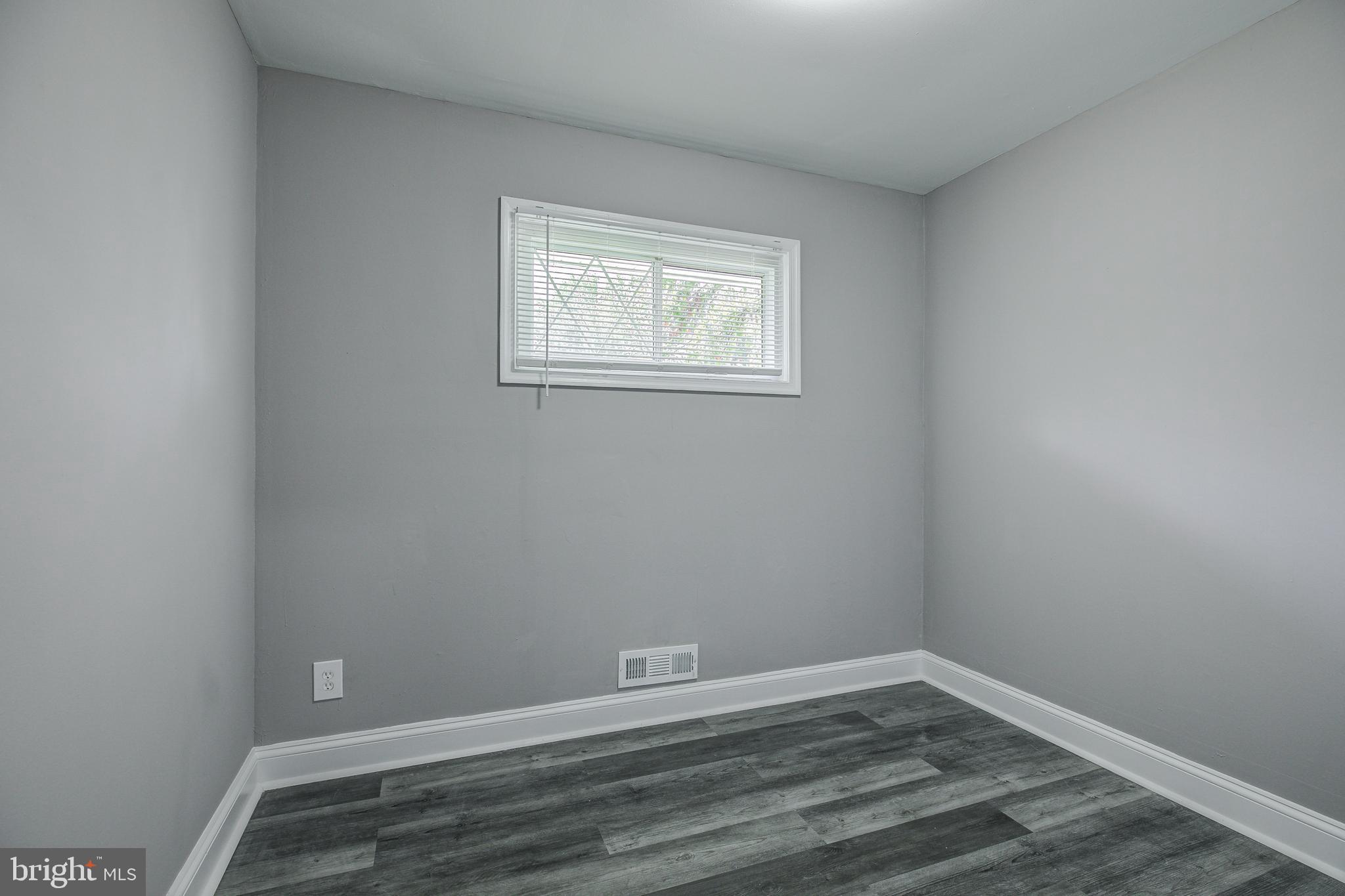 7410 Remoor Road Baltimore, MD 21207 - Photo 21 of 33 a view of an empty room with wooden floor and a window