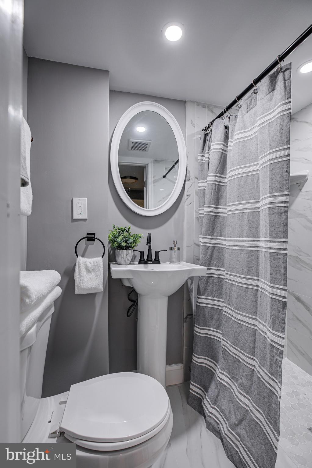 7410 Remoor Road Baltimore, MD 21207 - Photo 29 of 33 a bathroom with a sink a mirror a toilet and a mirror