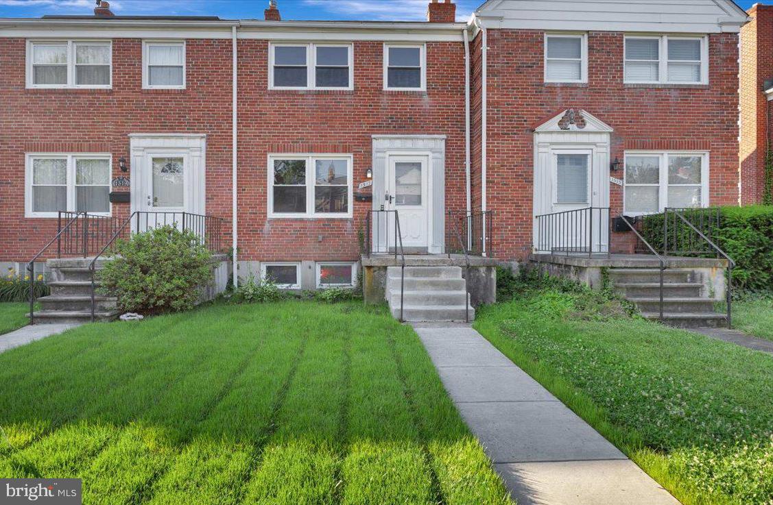 front view of a brick house with a yard