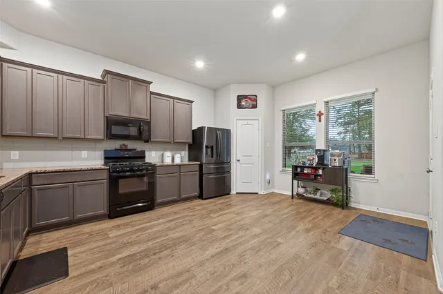 a kitchen with stainless steel appliances a microwave a sink and a refrigerator