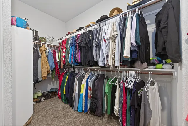 a view of walk in closet with clothes