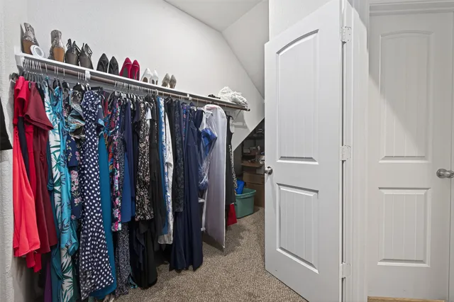 a view of walk in closet with clothes