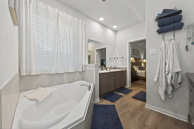 a bathroom with a tub sink and mirror