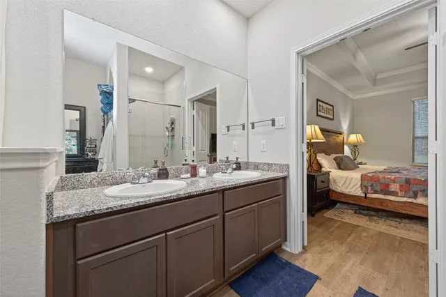 a en suite bathroom with a granite countertop sink and a mirror