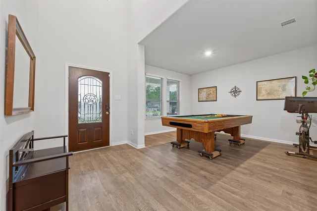a room with furniture pool table and wooden floor