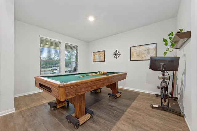 a room with pool table and windows