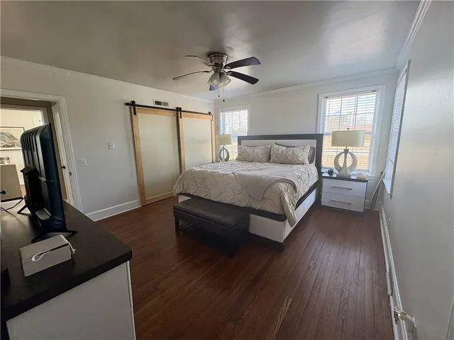 a bedroom with a bed and a flat tv screen on the dresser