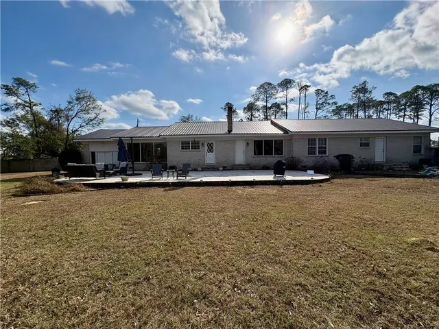 a front view of a building with river and trees
