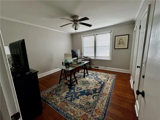 a workspace room with wooden floor and a ceiling fan