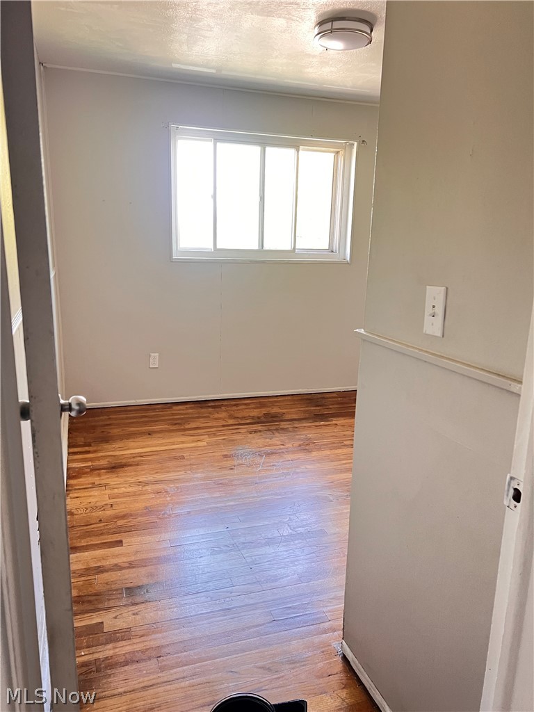 16350 Rockside Road Maple Heights, OH 44137 - Photo 19 of 34 Room featuring wood-finish flooring, a multi-pane window, flush-mount ceiling light fixture, and light-toned walls