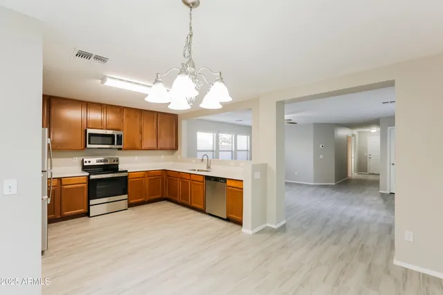 a large kitchen with stainless steel appliances granite countertop a stove and cabinets with wooden floor