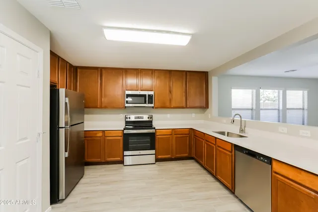 a kitchen with stainless steel appliances granite countertop a sink stove and refrigerator