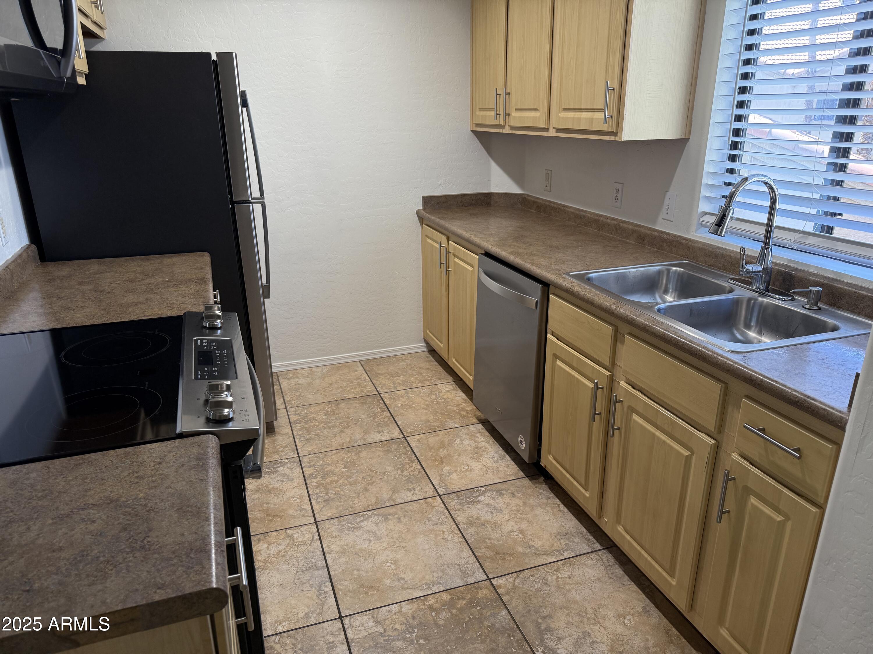 1287 North Alma School Road, Unit 260 Chandler, AZ 85224 - Photo 2 of 20 a kitchen with stainless steel appliances granite countertop a sink stove and cabinets