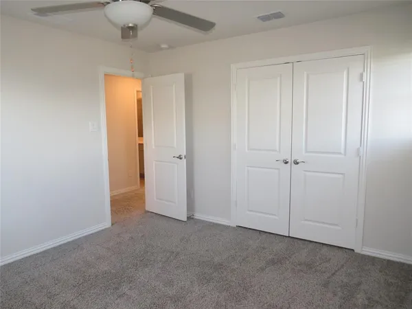an empty room with chandelier fan