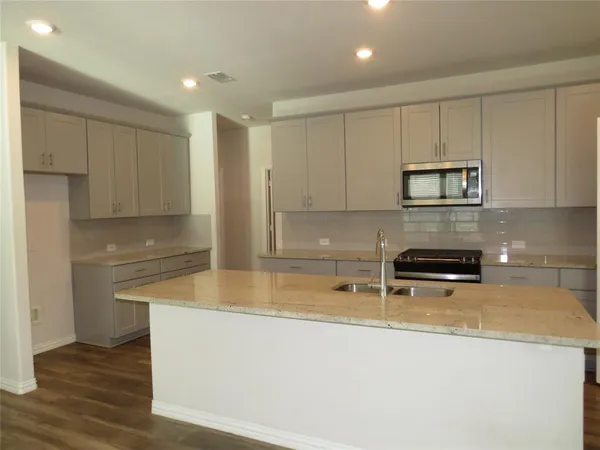 a kitchen with kitchen island a counter space and cabinets