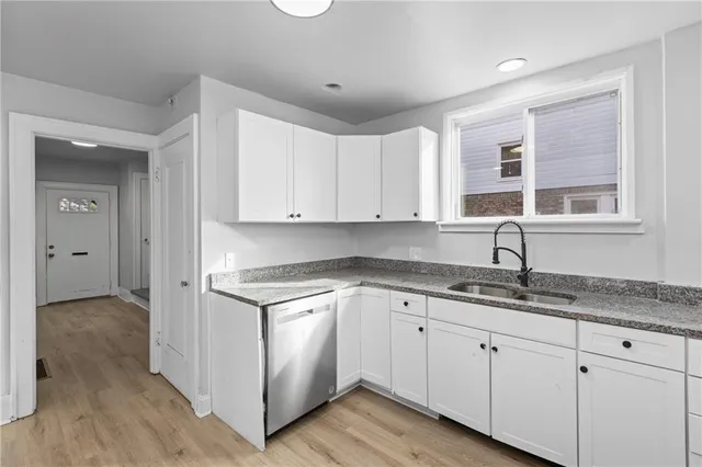a kitchen with granite countertop white cabinets and white appliances