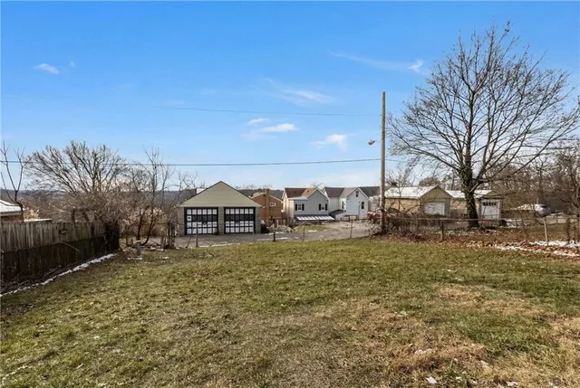 a large house with a big yard and large trees