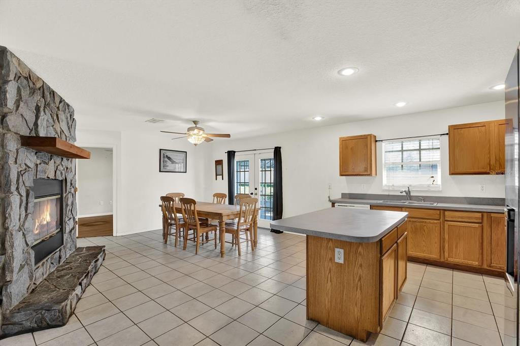 8240 Neda Street Spring Hill, FL 34606 - Photo 15 of 53 a dining hall with stainless steel appliances granite countertop a stove a sink a oven a dining table and chairs