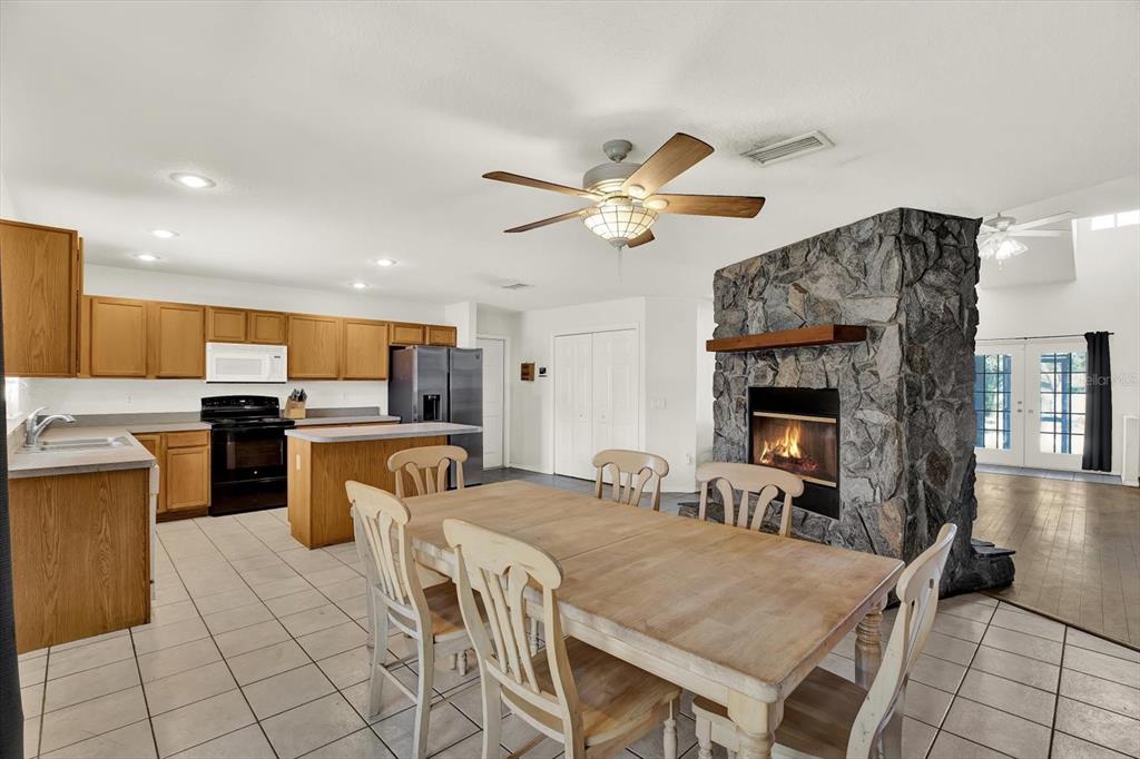 8240 Neda Street Spring Hill, FL 34606 - Photo 18 of 53 a living room with furniture a fireplace and kitchen view
