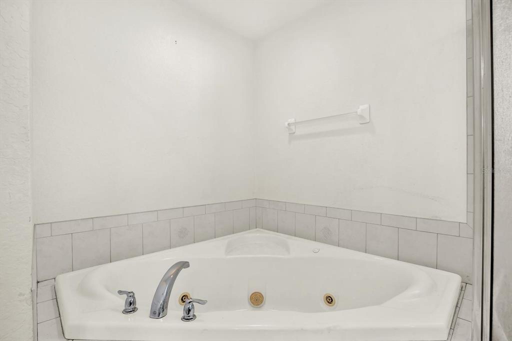 8240 Neda Street Spring Hill, FL 34606 - Photo 24 of 53 a bathroom with a white bath tub and a shower