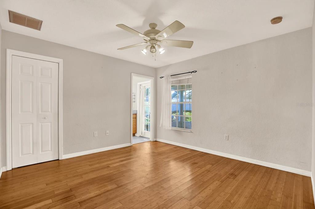 8240 Neda Street Spring Hill, FL 34606 - Photo 25 of 53 an empty room with wooden floor fan and windows