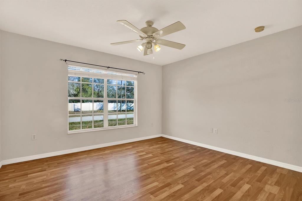 8240 Neda Street Spring Hill, FL 34606 - Photo 33 of 53 a view of an empty room with wooden floor and a window