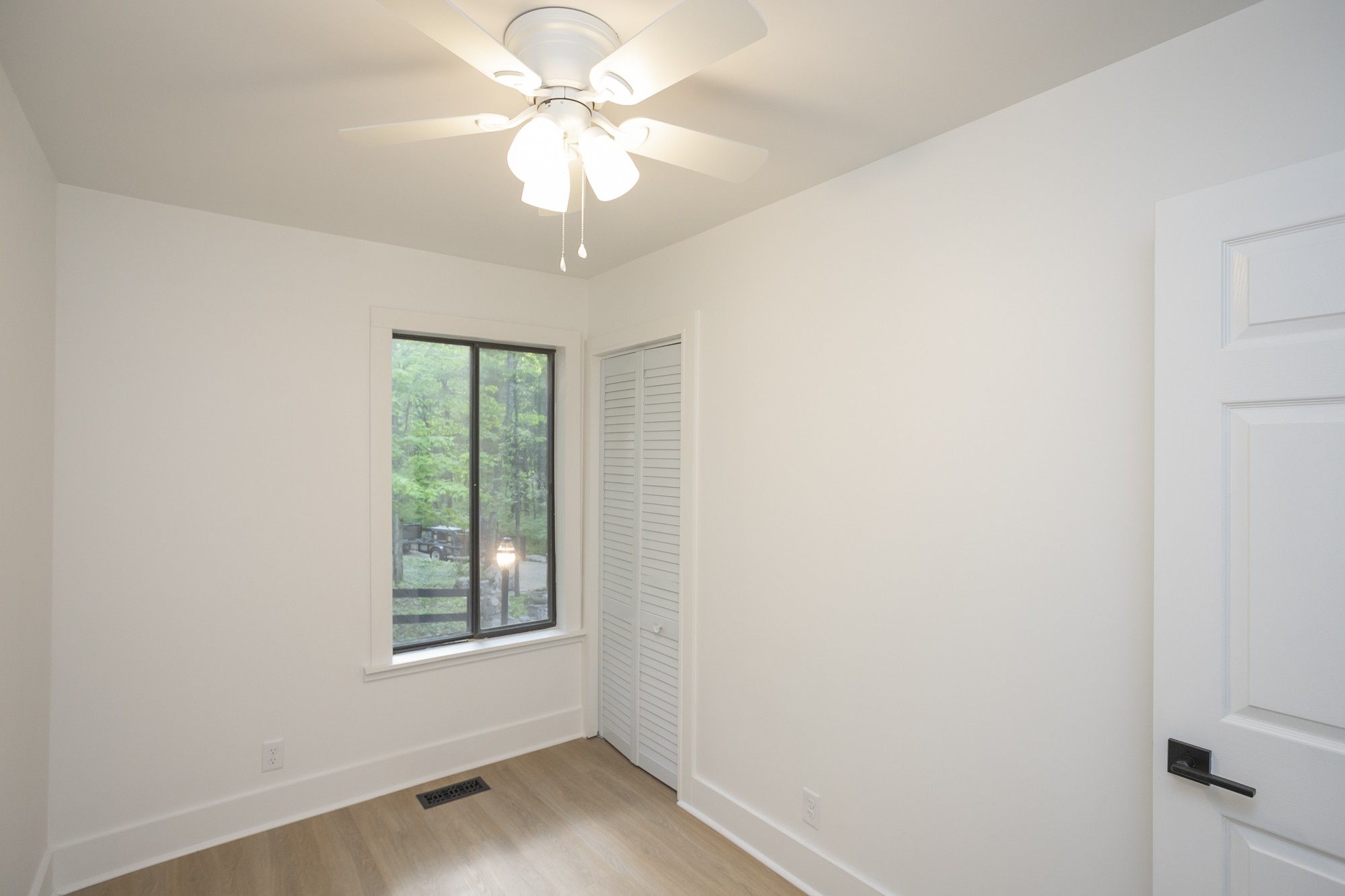 5860 Cane Ridge Road Antioch, TN 37013 - Photo 15 of 46 an empty room with wooden floor chandelier fan and windows