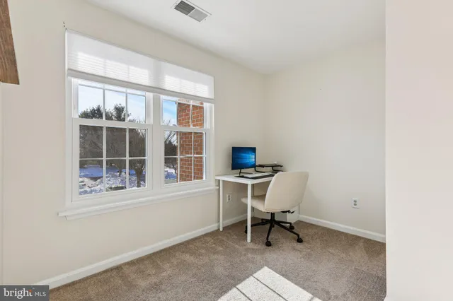 a view of a workspace with furniture and a window