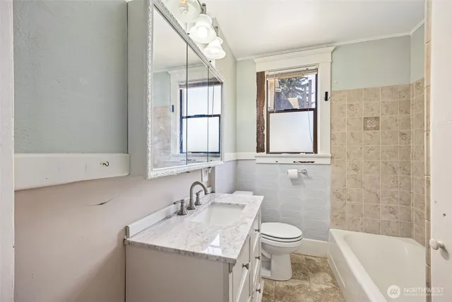a bathroom with a granite countertop sink toilet and shower