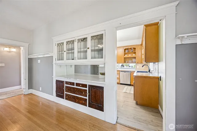 a view of kitchen with stainless steel appliances wooden floor and living room