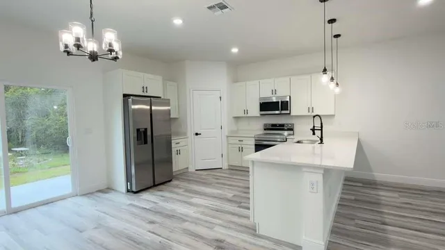 a kitchen with stainless steel appliances a refrigerator sink and microwave