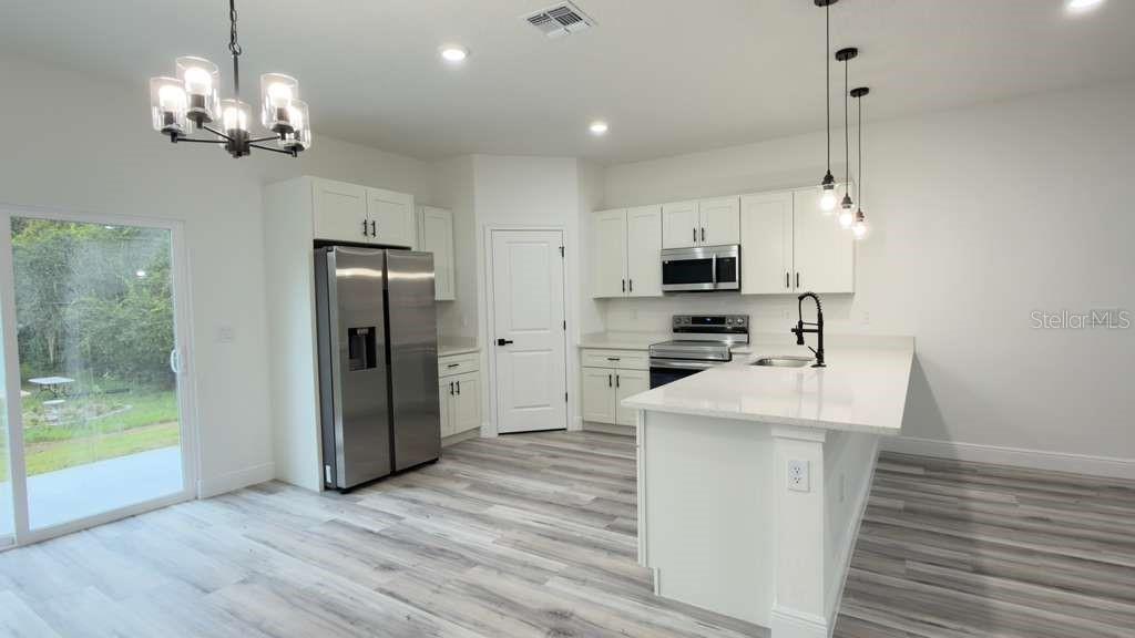 14905 Southwest 24th Circle Ocala, FL 34472 - Photo 6 of 24 a kitchen with stainless steel appliances a refrigerator sink and microwave