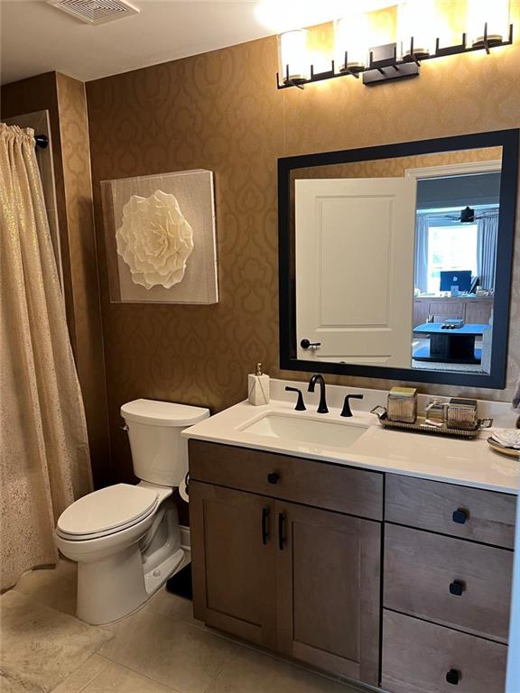704 Calypso Way Cumming, GA 30040 - Photo 12 of 33 a bathroom with a toilet sink and mirror