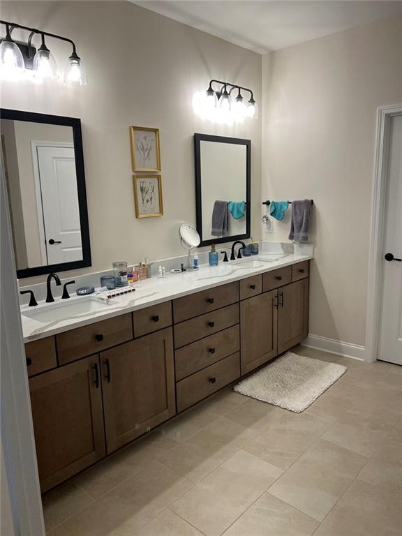 704 Calypso Way Cumming, GA 30040 - Photo 21 of 33 a bathroom with a double vanity sink and a mirror