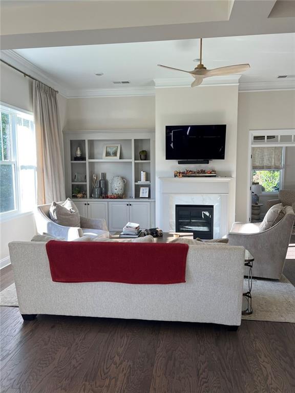 704 Calypso Way Cumming, GA 30040 - Photo 7 of 33 a living room with furniture a flat screen tv and a fireplace