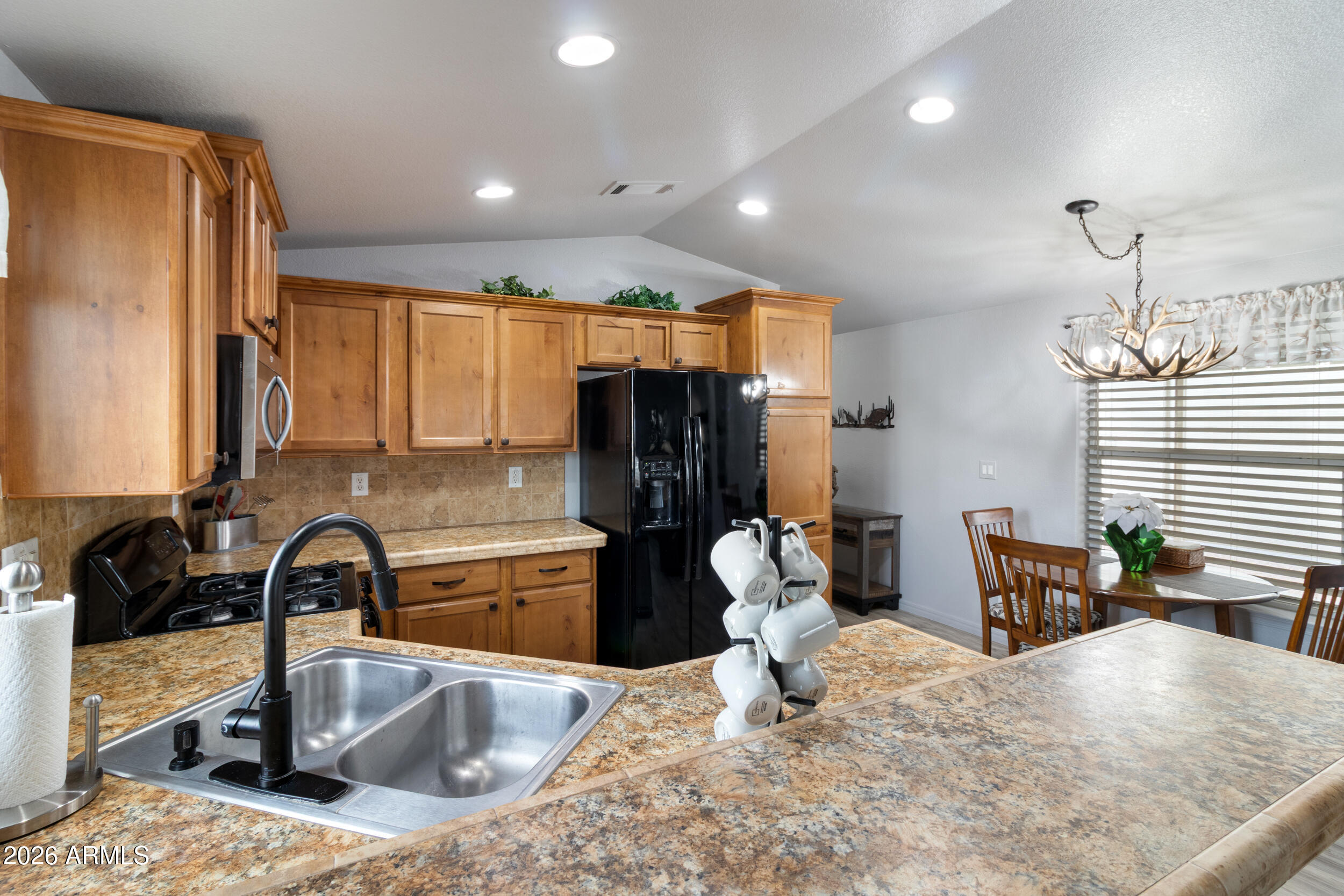 10936 East Apache Trail, Unit 121 Apache Junction, AZ 85120 - Photo 5 of 10 a kitchen with a sink and a refrigerator