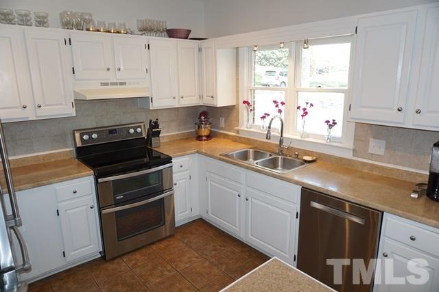 215 Danforth Drive Cary, NC 27511 - Photo 4 of 25 a kitchen with granite countertop a sink stainless steel appliances and cabinets