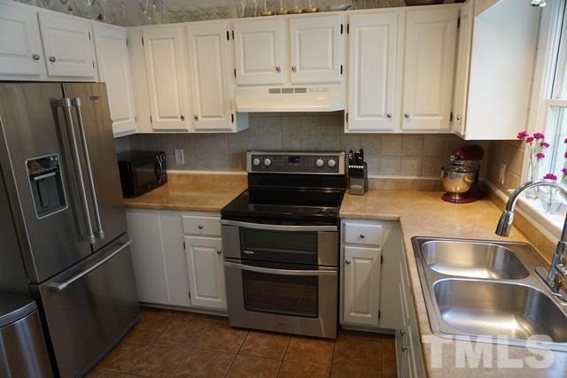 215 Danforth Drive Cary, NC 27511 - Photo 5 of 25 a kitchen with refrigerator and cabinets