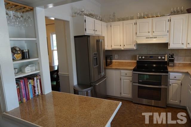 215 Danforth Drive Cary, NC 27511 - Photo 6 of 25 a kitchen with stainless steel appliances a refrigerator a stove a sink and a refrigerator
