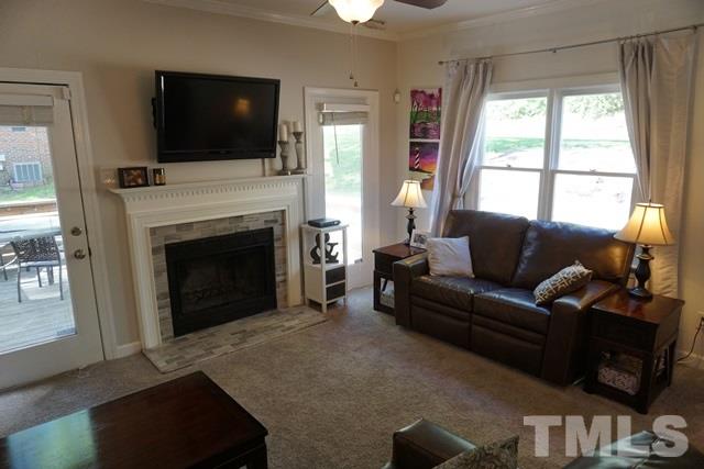 215 Danforth Drive Cary, NC 27511 - Photo 9 of 25 a living room with furniture a flat screen tv and a fireplace