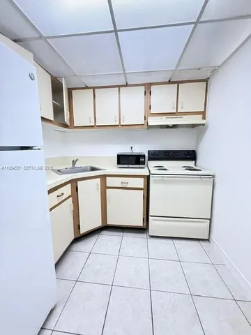a kitchen with a stove top oven sink and cabinets