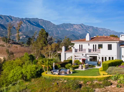 a living room with furniture fireplace and large windows