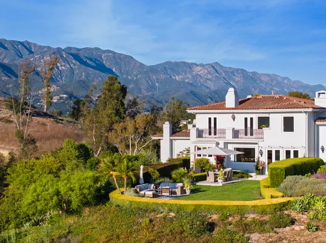 a living room with furniture fireplace and large windows