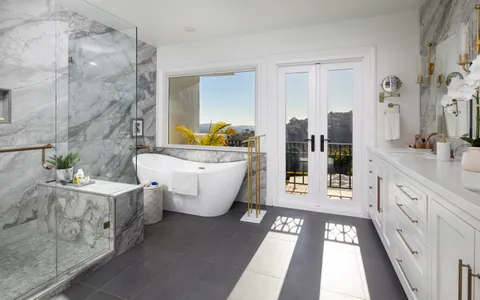 a bathroom with a double vanity sink a mirror a bathtub and next to a window
