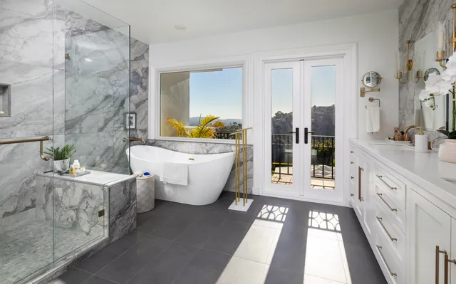 a bathroom with a double vanity sink a mirror a bathtub and next to a window