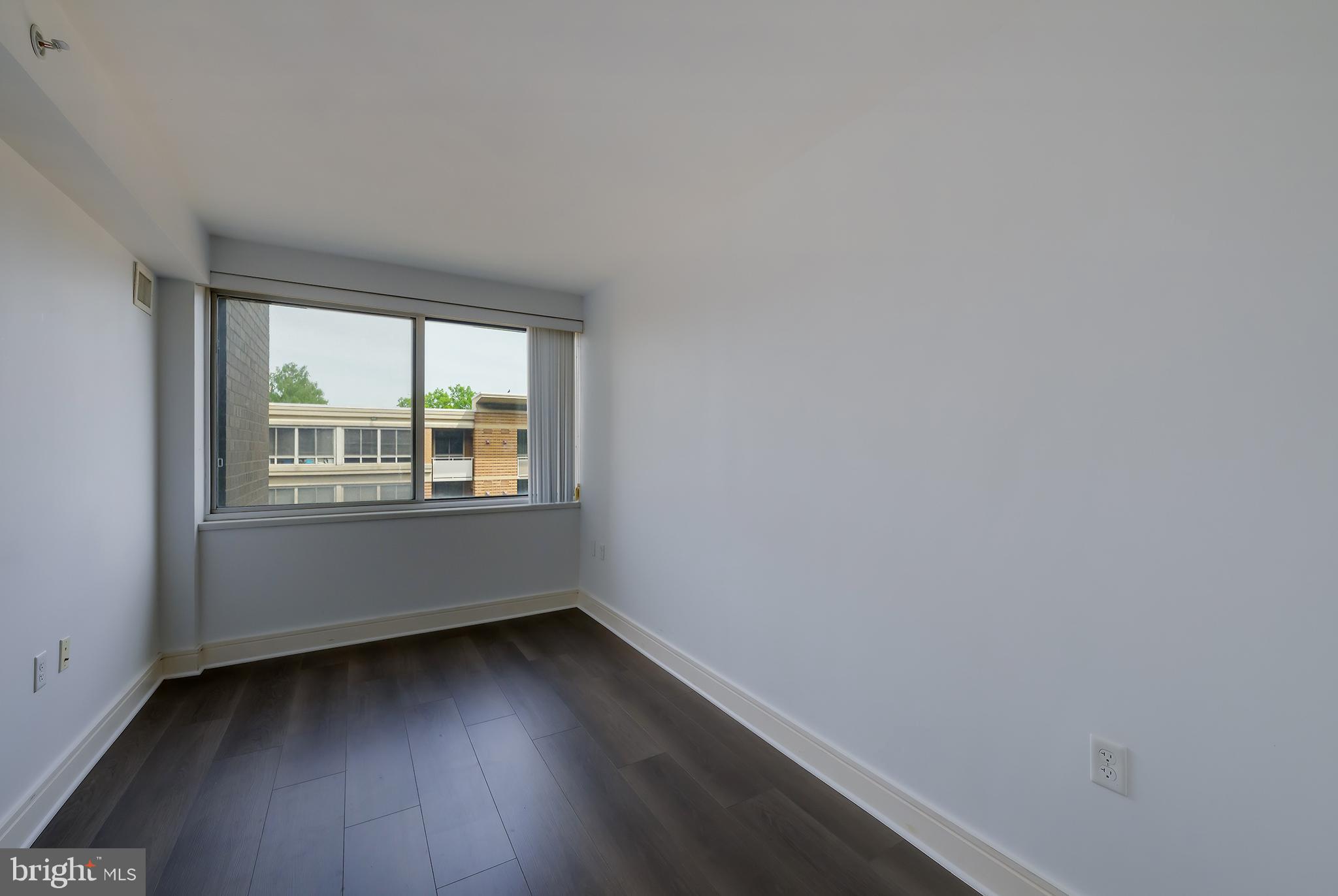 800 4th Street Southwest, Unit N518 Washington, DC 20024 - Photo 13 of 26 an empty room with wooden floor and windows