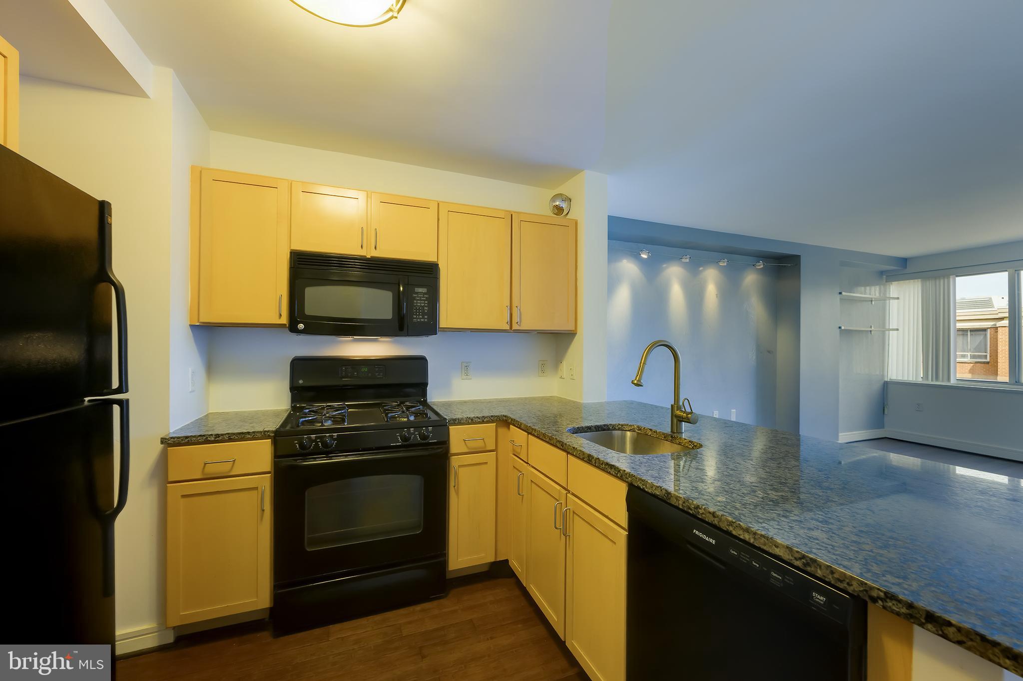 800 4th Street Southwest, Unit N518 Washington, DC 20024 - Photo 5 of 26 a kitchen with stainless steel appliances granite countertop a stove a sink and a refrigerator