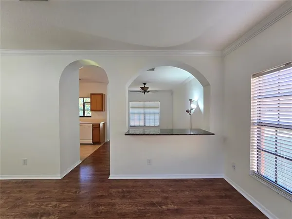 a view of a living room with a window and wooden floor